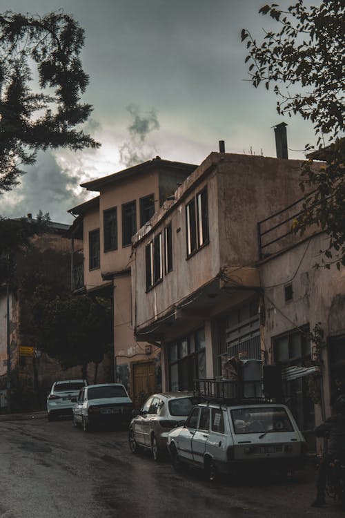 Cars Parked along the Street next to Residential Buildings in City 