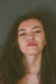 一位黑发女子的特写肖像自然美丽，柔和的灯光让她的五官更加立体