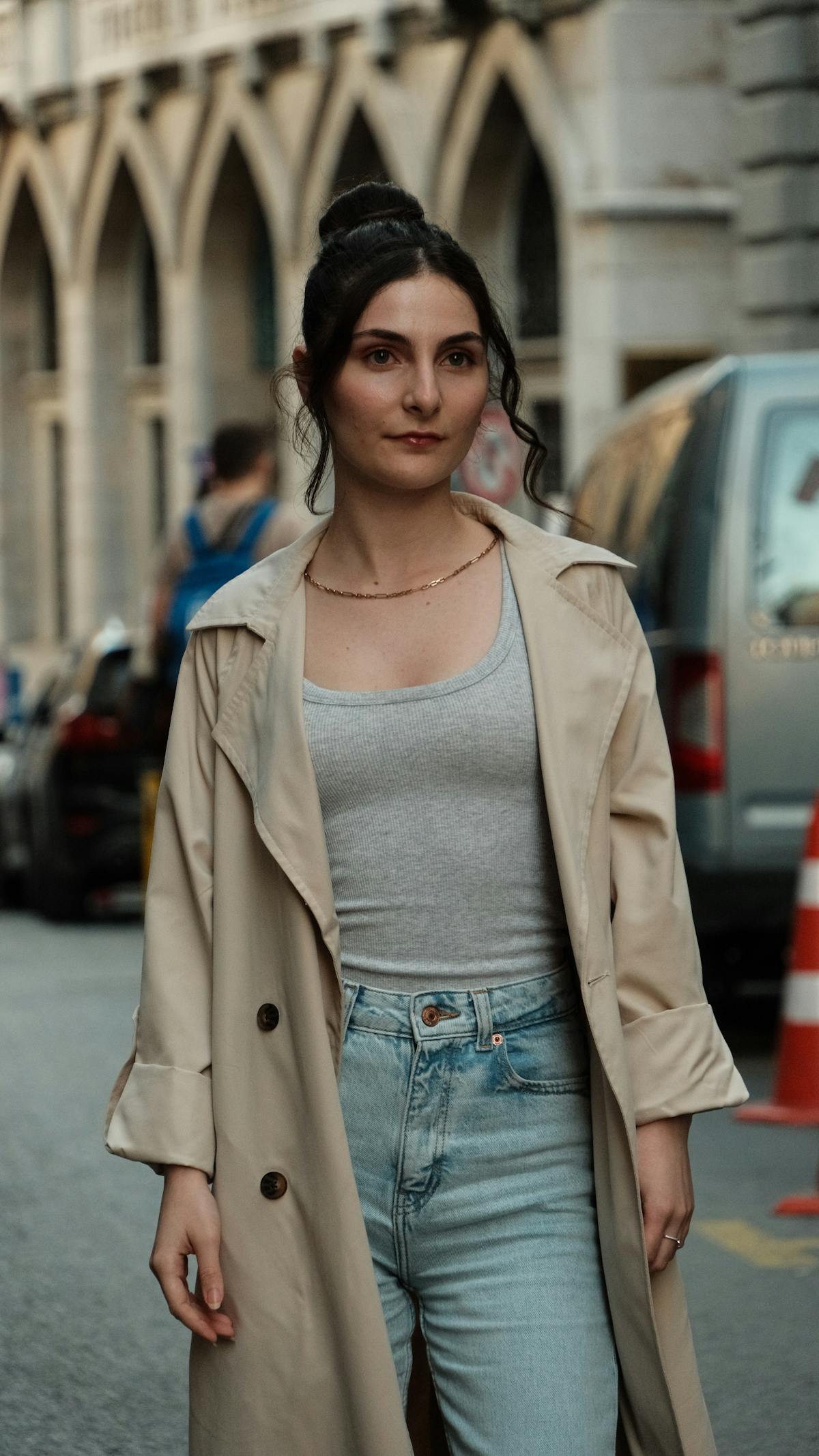 Ritratto street-style di una donna con trench beige e strati leggeri
