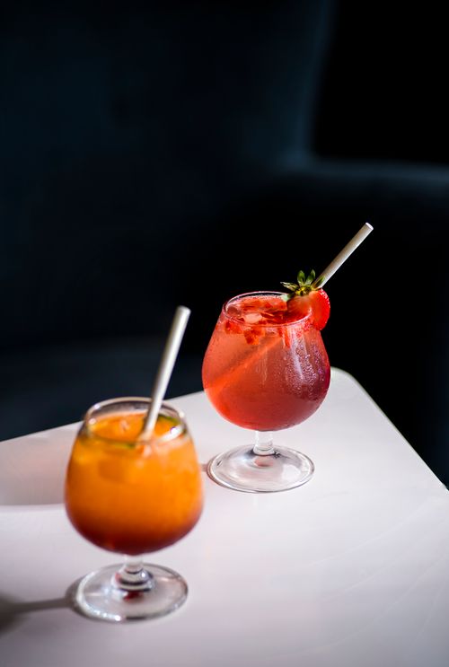 Free Two vibrant cocktails with straws on a minimalist table, ideal for a refreshing drink. Stock Photo