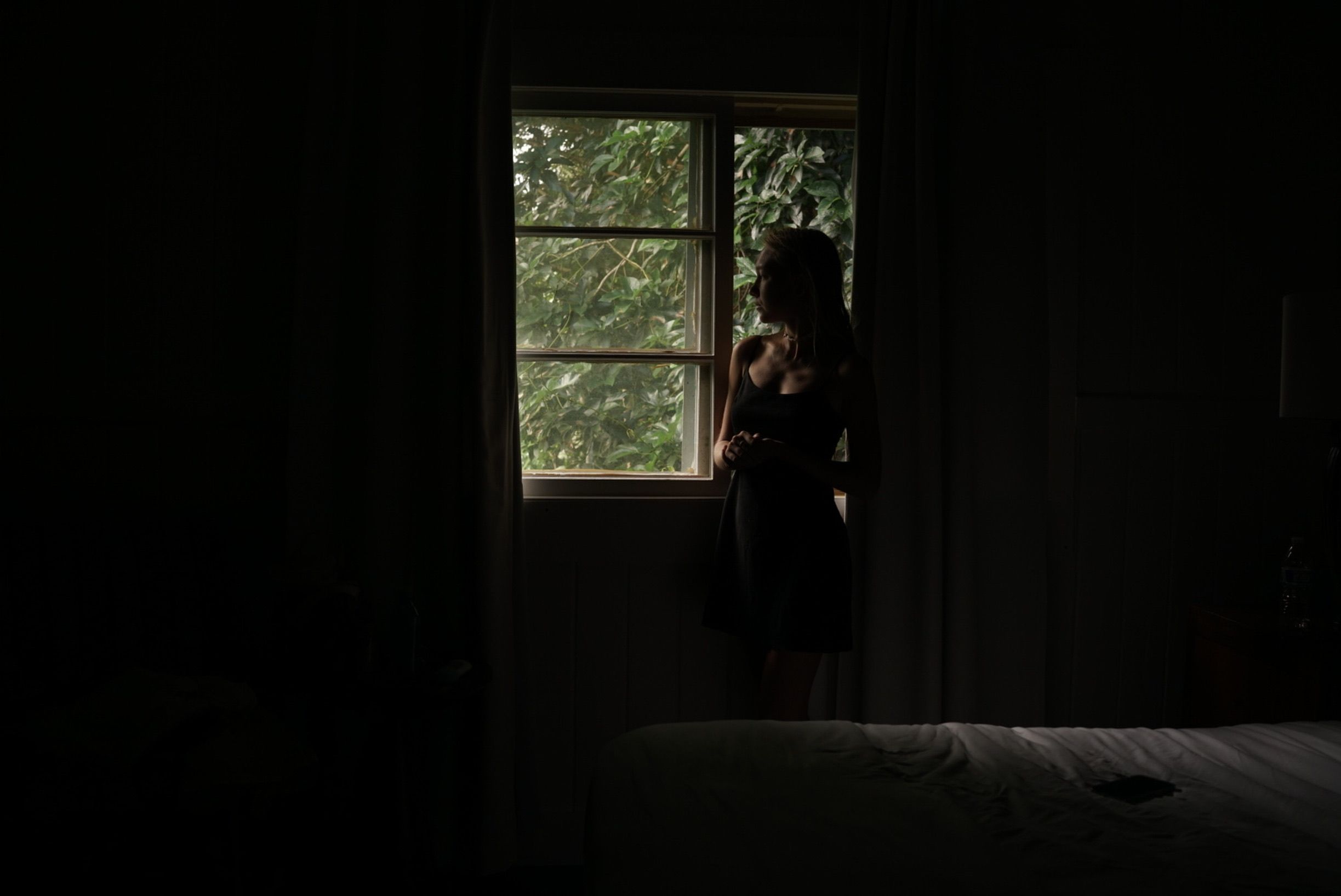 Woman Standing by the Window in a Dark Room · Free Stock Photo