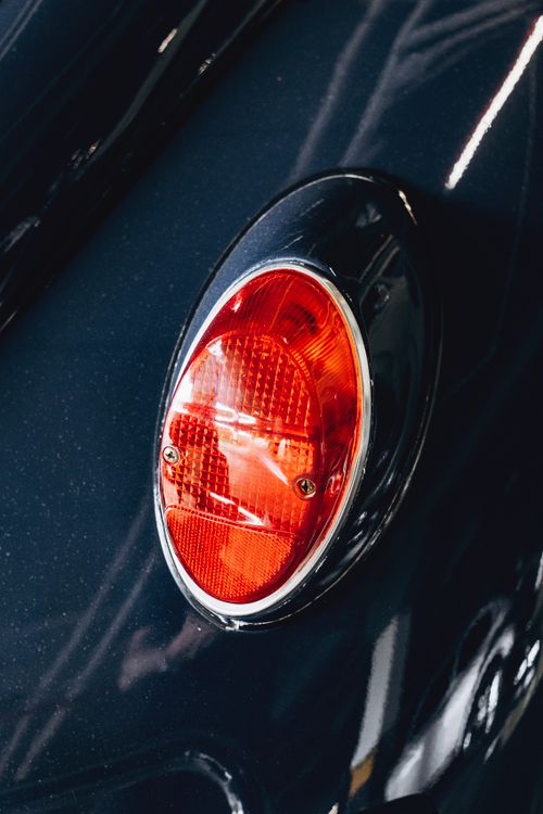 Free Detailed close-up of an oval red tail light on a black car, showcasing design and craftsmanship. Stock Photo