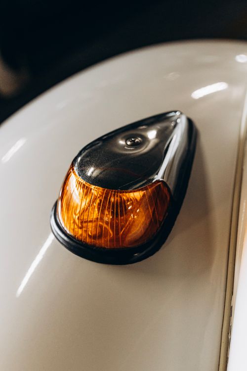 Free Close-up shot of a vintage Volkswagen Beetle turn signal with warm lighting. Stock Photo
