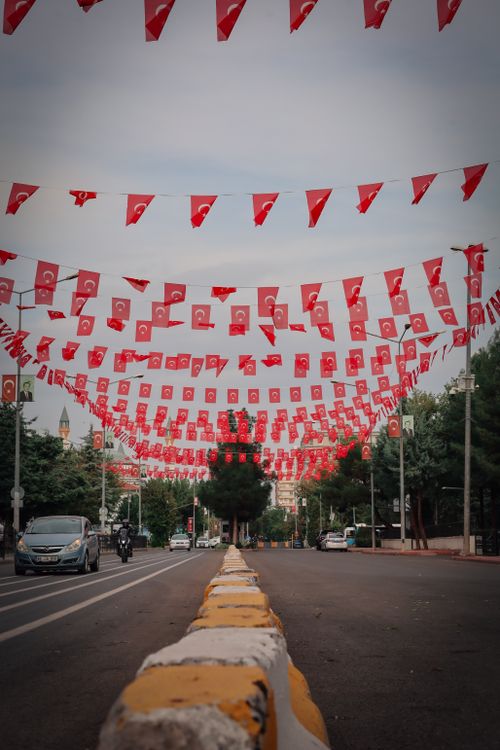 Free Urban scene with vibrant red flags hanging over a city street, creating a festive atmosphere. Stock Photo