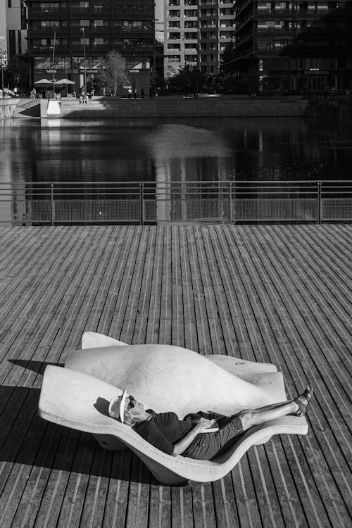 Woman Lying Down on Sunbed on Pier in Black and White