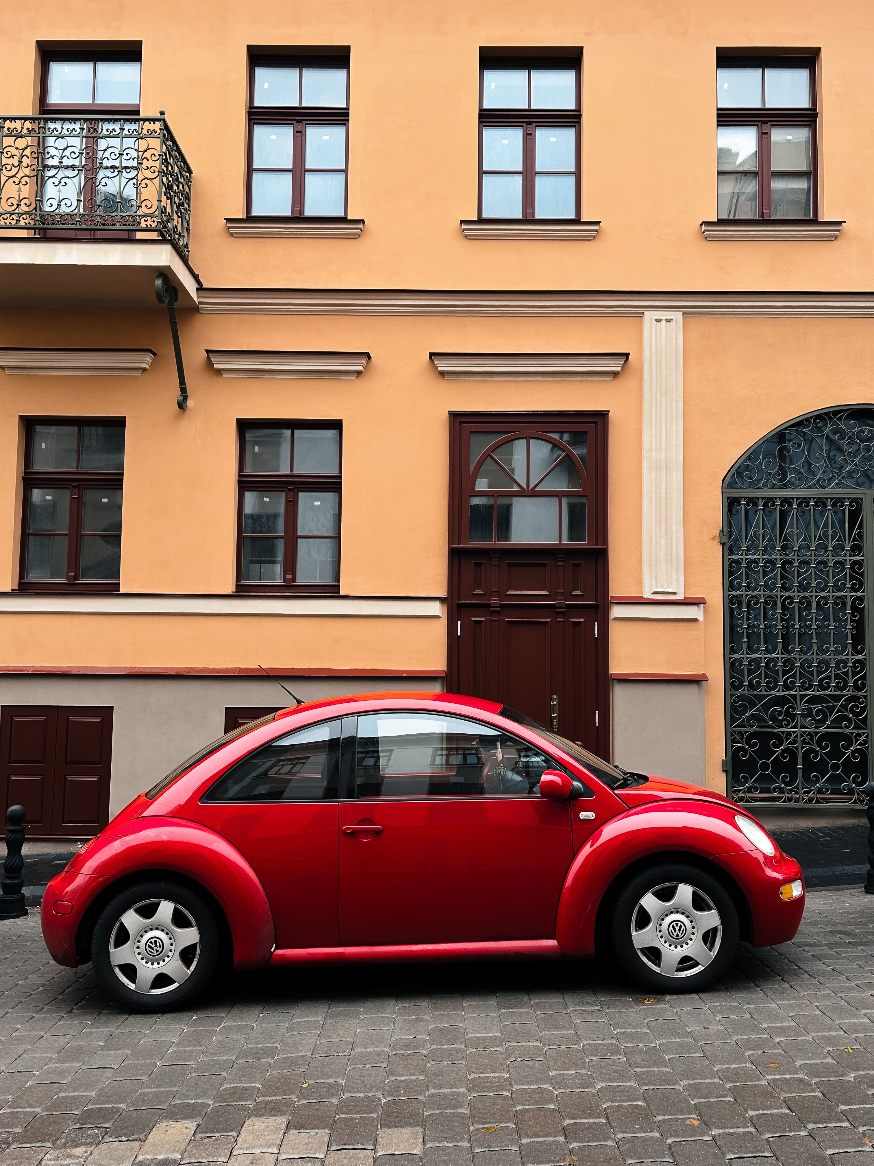 A Red Volkswagen Beetle Parked in front of a Residential Building in ...