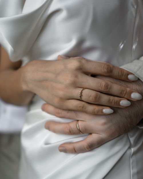 Free A touching close-up of newlyweds' hands adorned with wedding rings, signifying love and union. Stock Photo