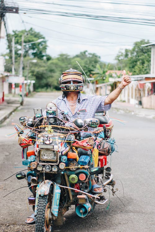 A Man Having a Bunch of Objects Tied to His Motorcycle 