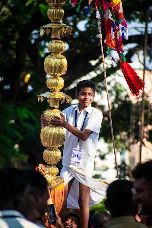 A Boy Standing on the Shoulders of a Man at a Parade 