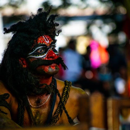 Man with a Face and Body Painting at a Festival 