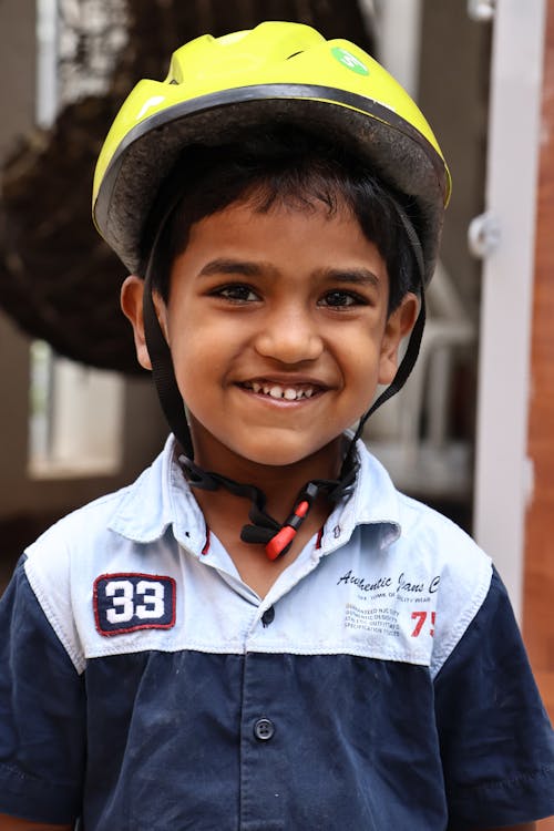 A smiling child wearing a helmet and smiling