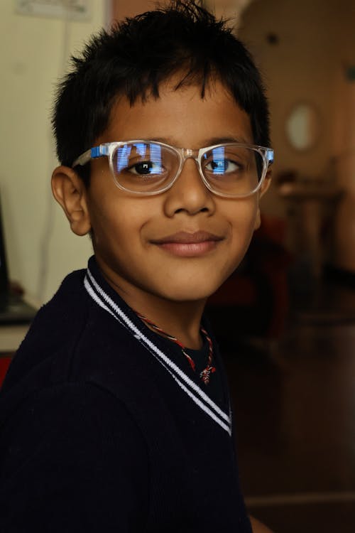 A young boy wearing glasses and smiling
