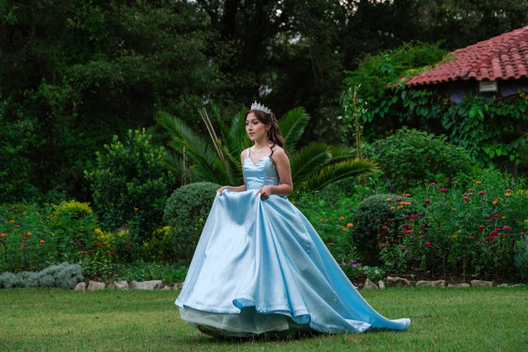 Woman In Blue Dress Walking In Garden