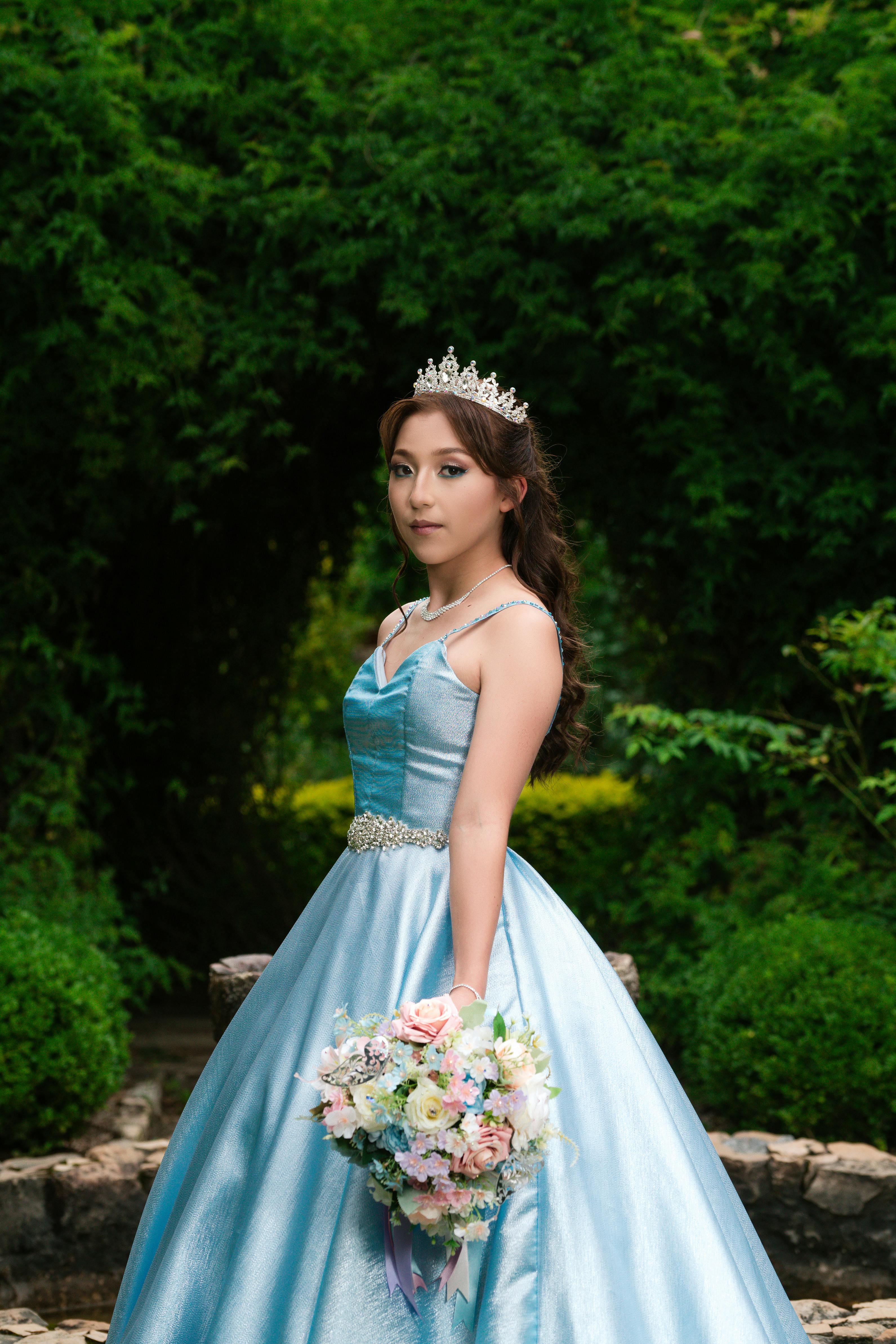 transform the girl in the image into a majestic princess. enhance her  beauty with a regal gown adorned with intricate details. add a sparkling  tiara on her head, fit for royalty. surround
