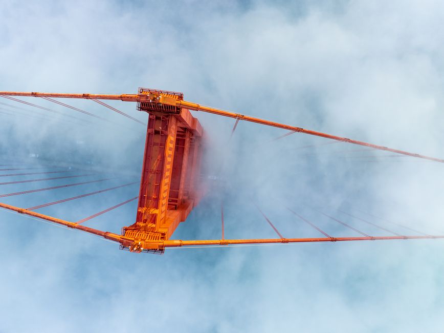 Stunning aerial shot of the Golden Gate Bridge emerging from the fog in San Francisco.