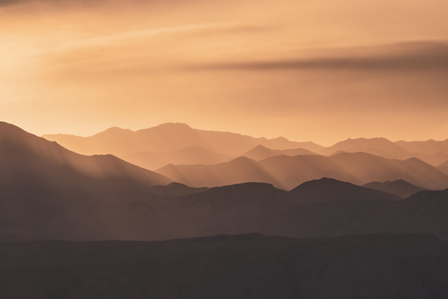 Layered mountain ridges at sunset above a growing region — photo by Zetong Li on Pexels