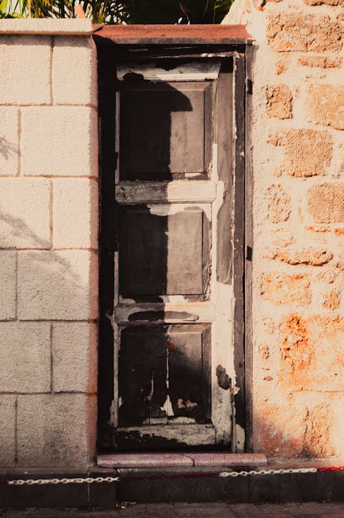 Wooden Narrow and Peeled Door in Wall 