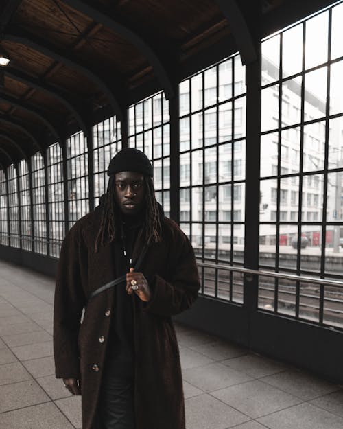 Man in Coat Standing in Tunnel