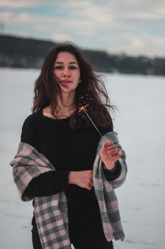 冬日雪景中，一名女子燃放烟花，温暖与欢乐随之弥漫