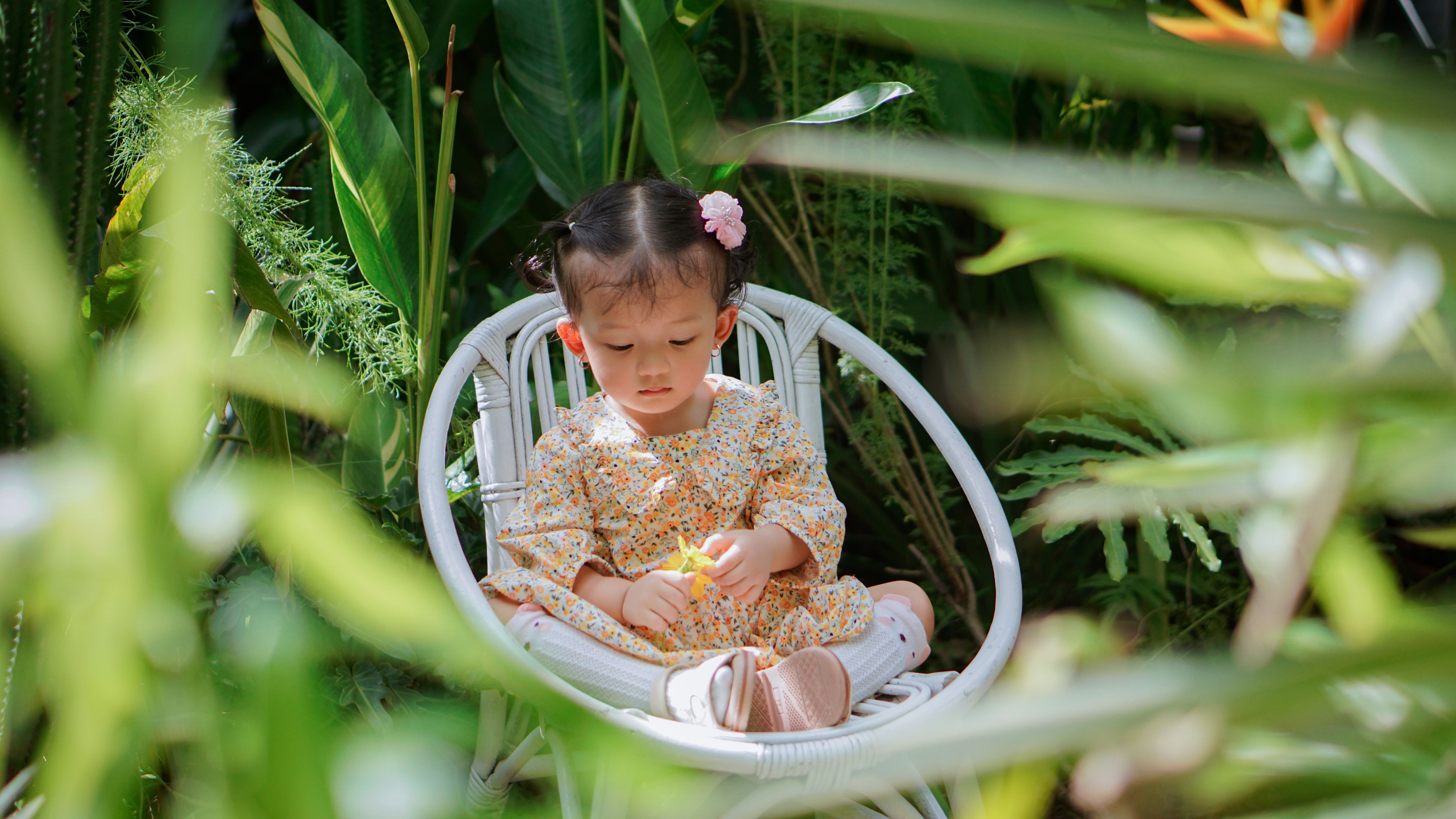 Little Girl Sitting in a Garden Chair · Free Stock Photo