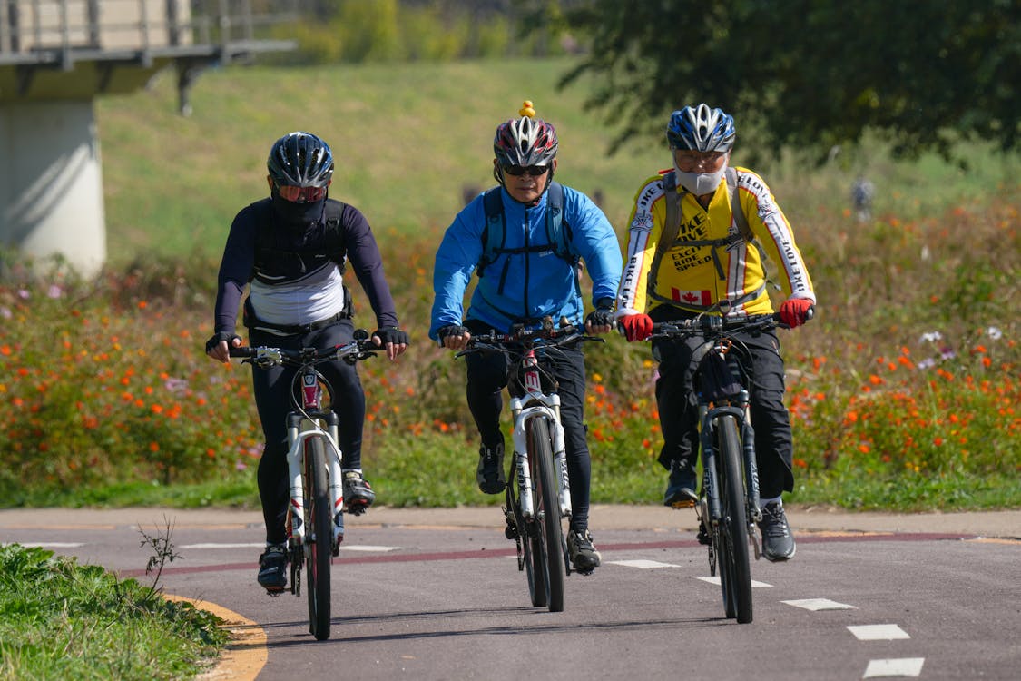 Cyclists in Helmets Riding Bikes