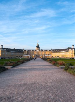 A scenic view of Karlsruhe Palace, Germany, with lush gardens under a clear blue sky.