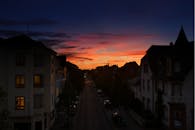 日落时分，城市街景如画，温暖的光芒洒在住宅建筑和晴朗的天空上