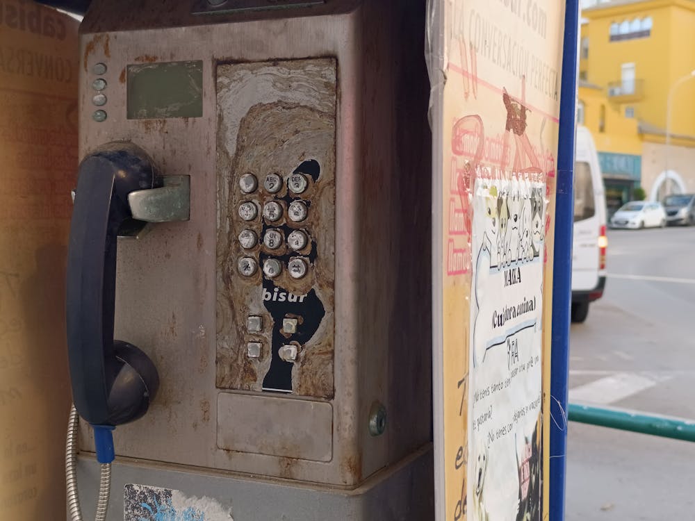 vieja cabina telefónica arrinconada en una acera de nuestra ciudad
