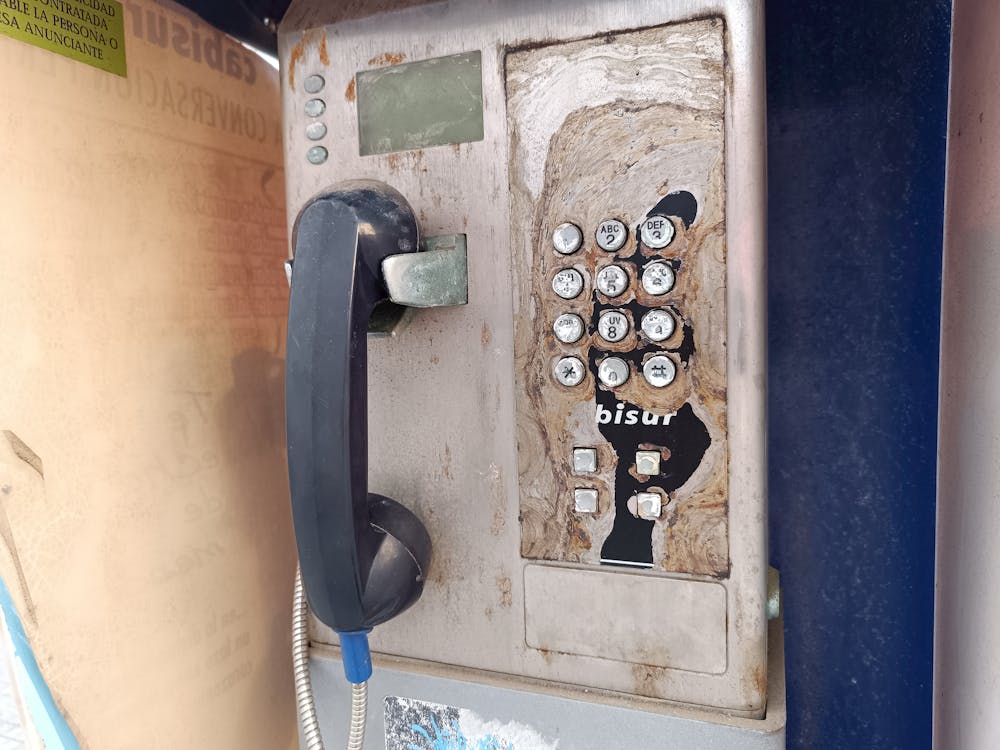 vieja cabina telefónica arrinconada en una acera de nuestra ciudad