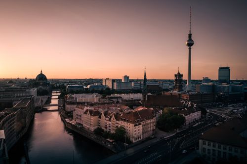 Free Aerial view of Berlin cityscape at sunset with the iconic Fernsehturm tower and Spree river. Stock Photo