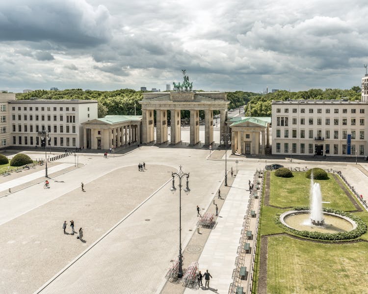 People Walking On Square Near City Historical Arch