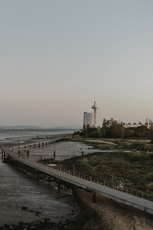 A long pier with a lighthouse in the distance