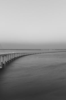 Monochrome image of the Vasco da Gama Bridge stretching over the Tagus River in Lisbon, Portugal.