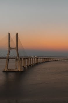 Stunning sunset view of Vasco da Gama Bridge stretching over the Tagus River in Lisbon, Portugal.
