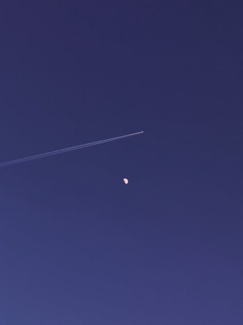 Plane Leaving Contrails Above the Moon