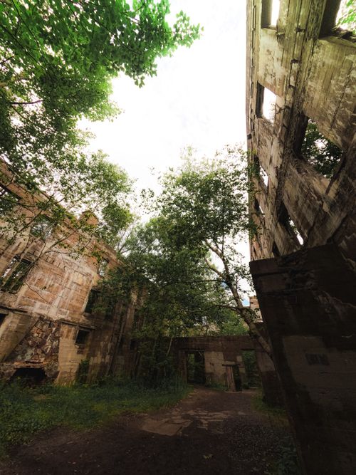 Free Explore the eerie beauty of abandoned building ruins in Catskill, NY, surrounded by lush trees. Stock Photo