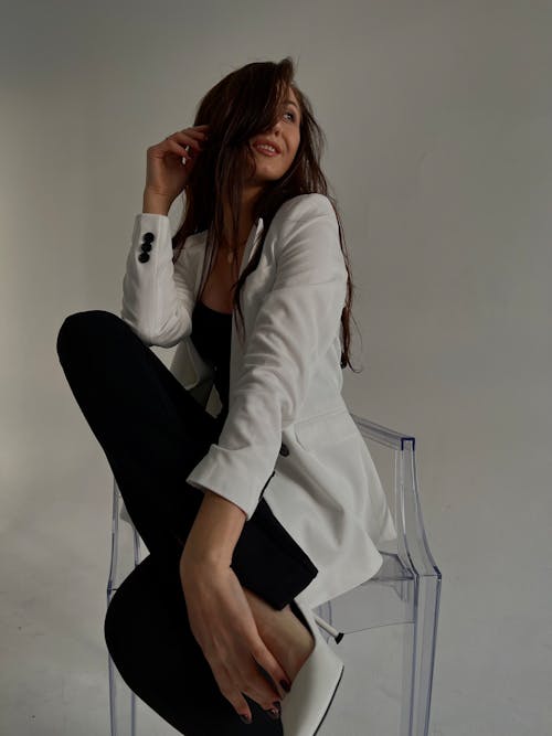 Model in White Jacket Posing on Chair