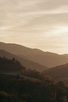 Peaceful mountain landscape with soft sepia tones at sunset, evoking serenity and tranquility.