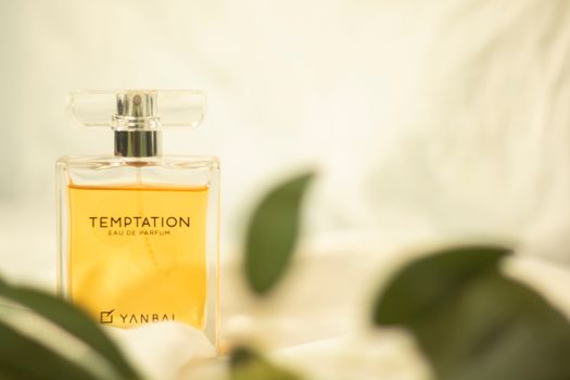 A bottle of temptation perfume on a white surface