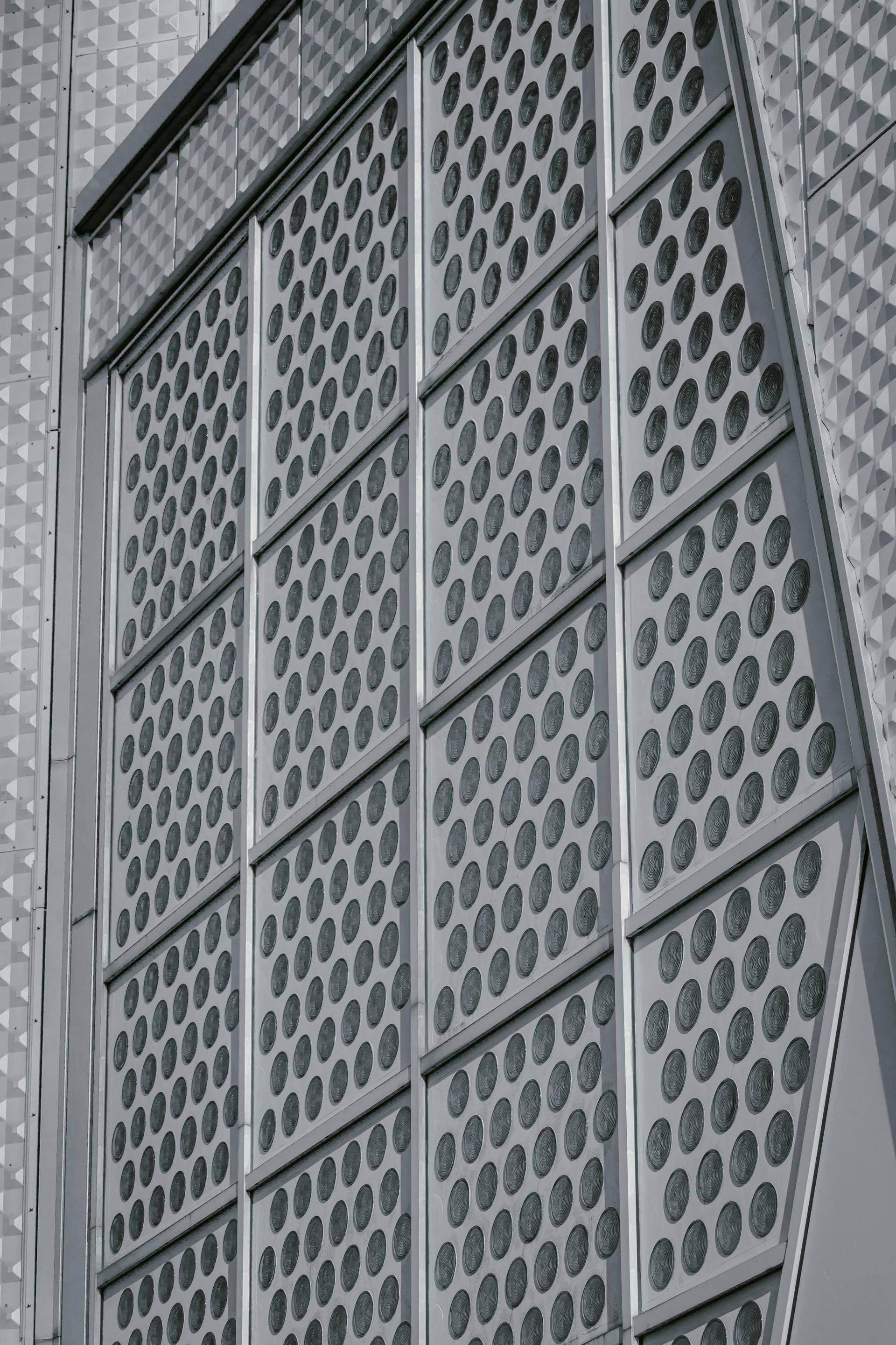 Modern architecture featuring a geometric metal facade with circular patterns.
