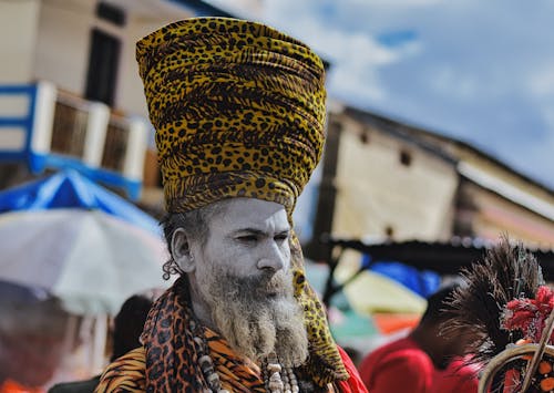 Hindu Sadhu with Face Painted White Wearing High Yellow Turban with Spots