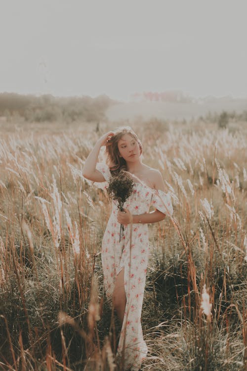 Portrait of a Beautiful Woman Standing in a Summer Field