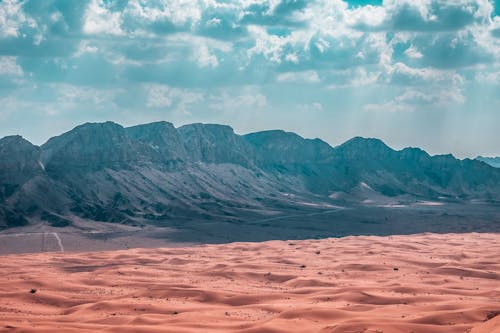 Clouds over a Barren Desert with Cliffs in the Background