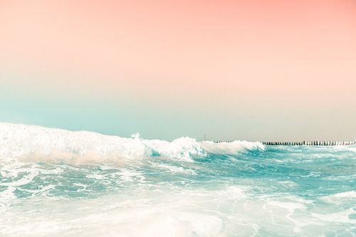 Free Serene seascape featuring gentle ocean waves under a pastel colored sunset sky, perfect for calm and relaxation themes. Stock Photo