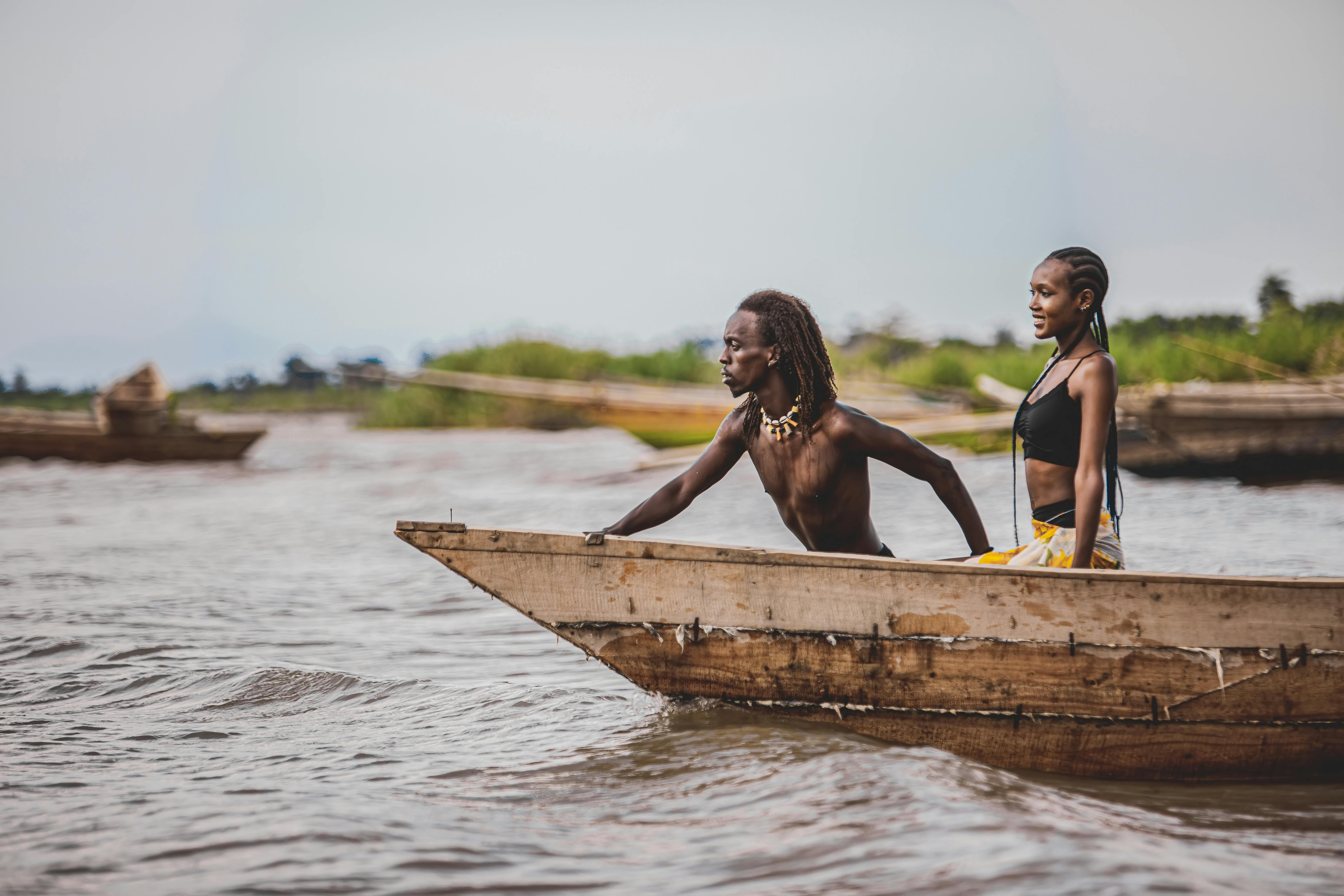 man pulling a wooden boat with his girlfriend