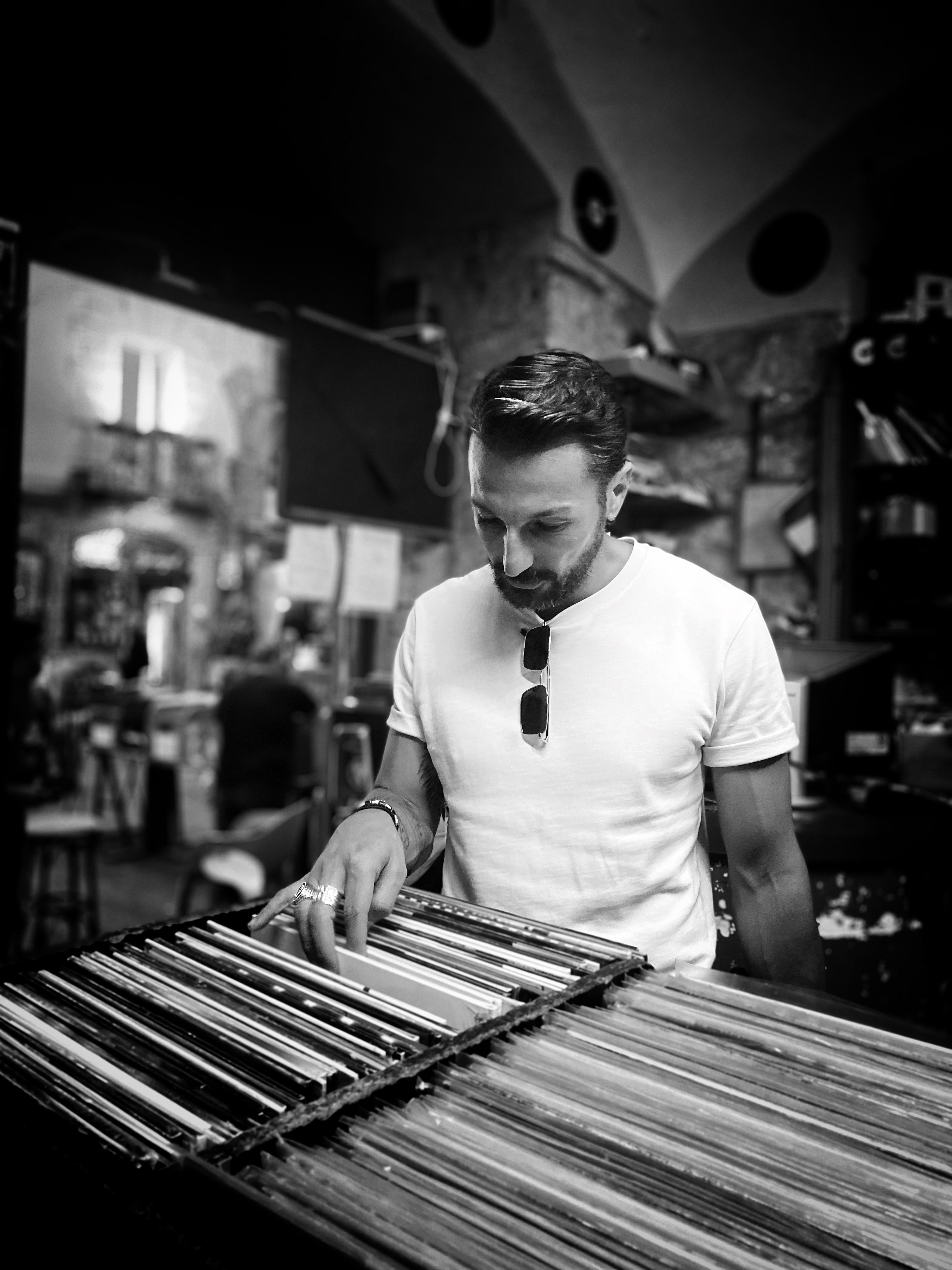 A man in a vintage record store in Napoli, exploring vinyl records with focus on classic music.