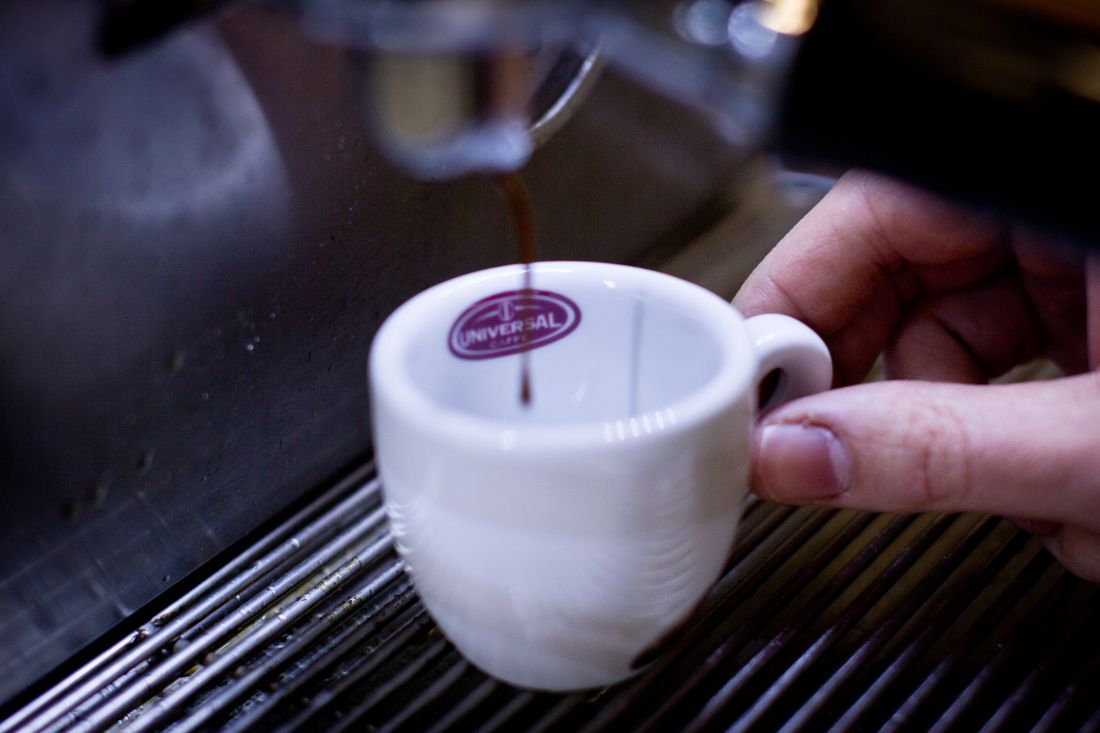 Espresso pouring into white cup