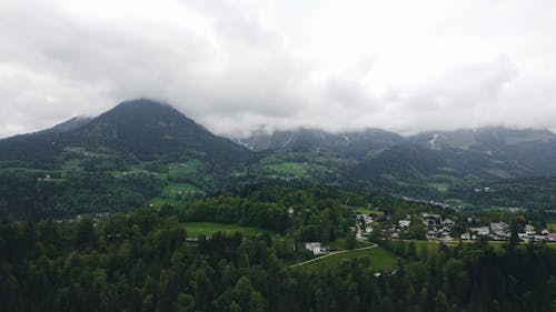 Mountains Covered by Clouds and a Village in a Valley 