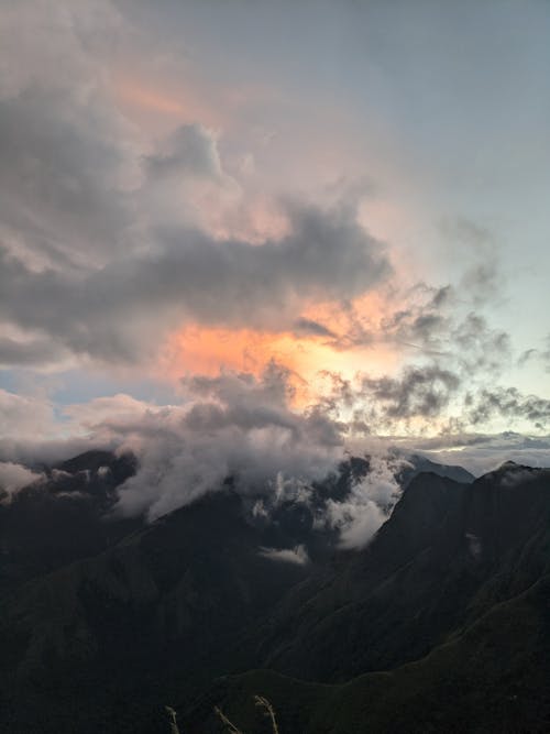 Clouds Covering the Mountain Peaks and Obscure the Setting Sun