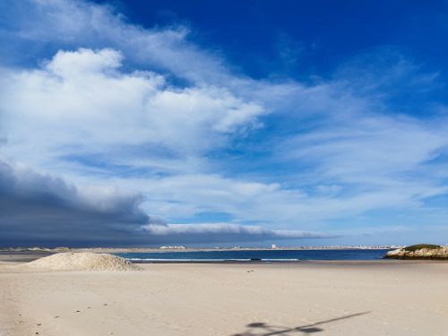 Free A scenic beach landscape on a bright summer day with dramatic clouds and a vast sandy shore. Stock Photo